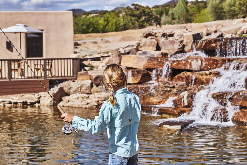 Girl fly fishing in a calm creek at Bishops Lodge