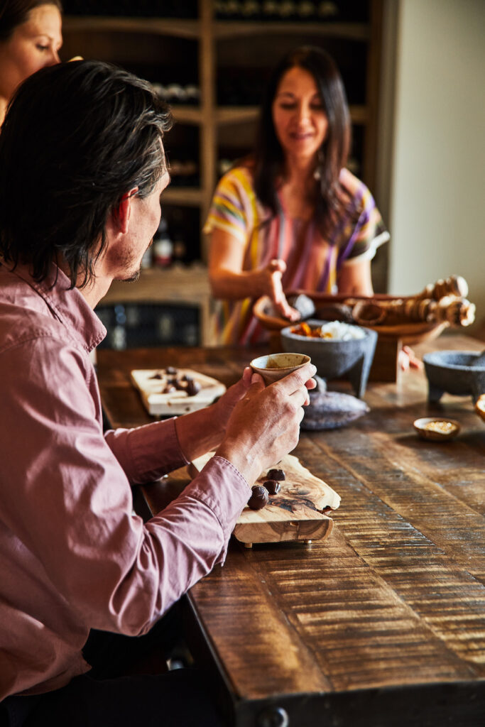 Group of individuals around a table making chocolate and participating in the chocolate immersion experience