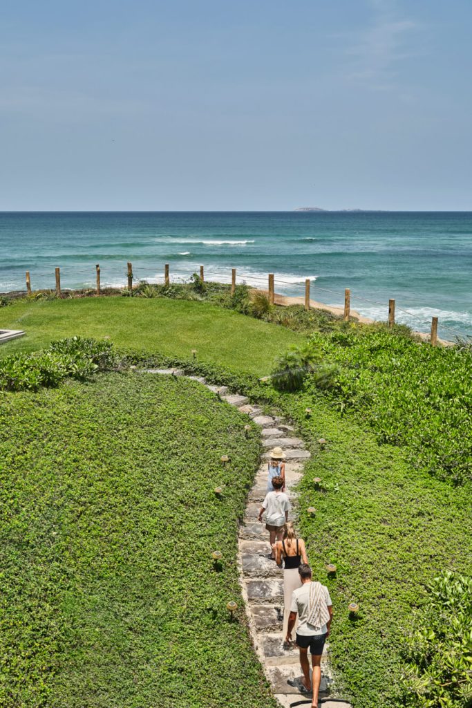 A family walking down a stone path by the ocean