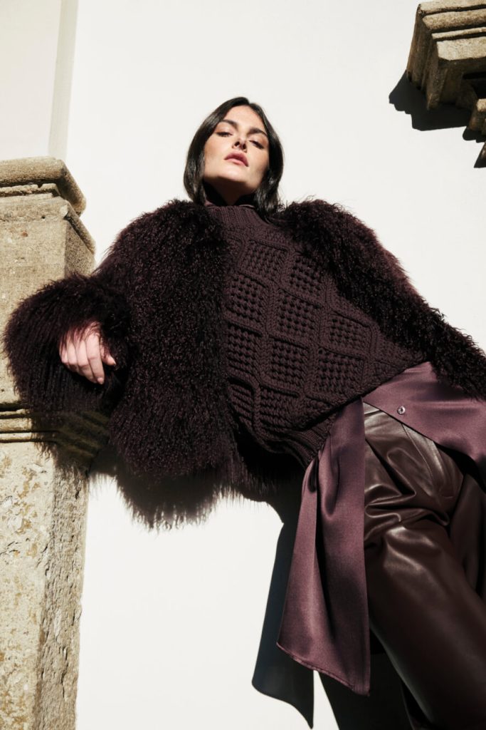 A female model for eleventy wearing dark purple clothes