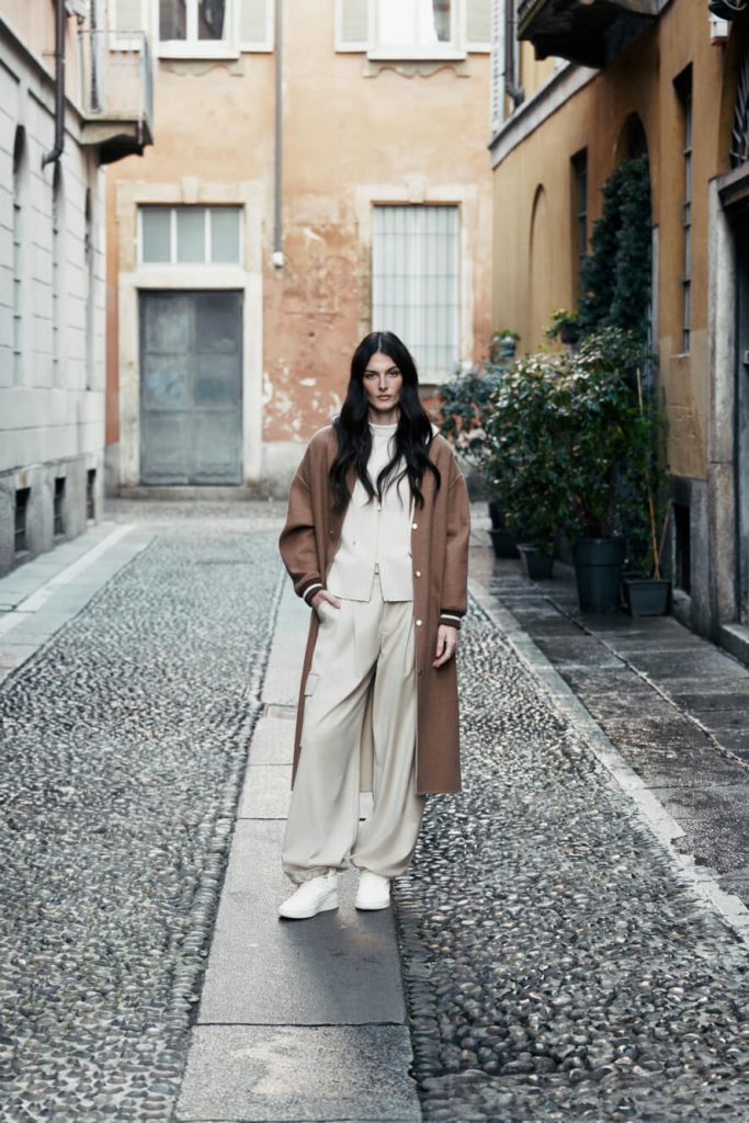 A model for Eleventy wearing beige and brown clothes