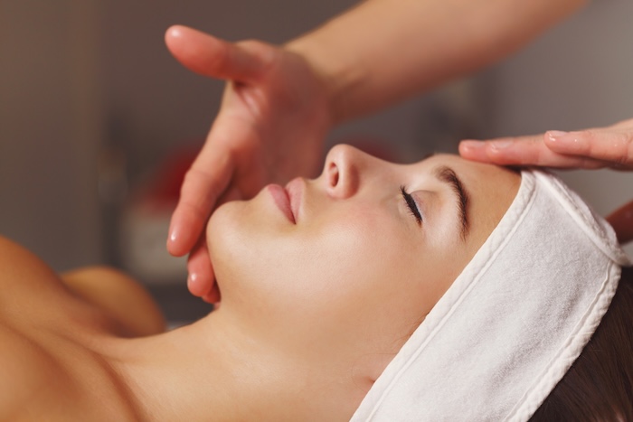 Woman lying down in a terry headband gets a spa treatment at Auberge du Soleil