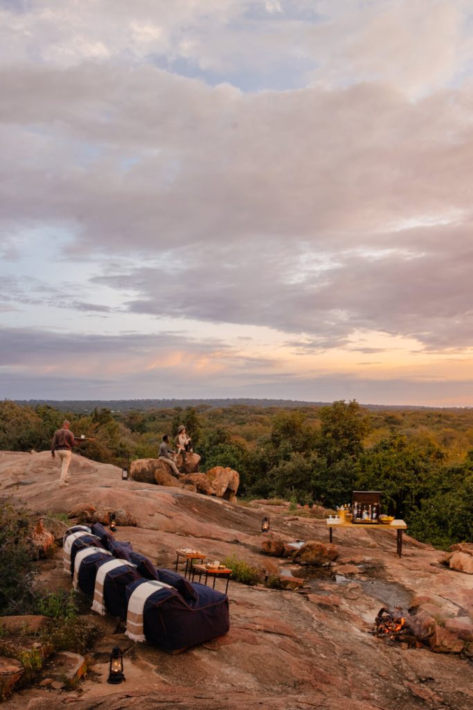 people on a rock at sunset